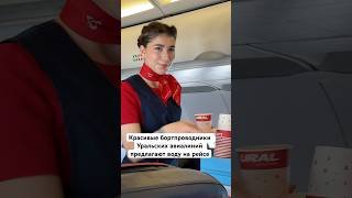 Красивые бортпроводники Уральских авиалиний предлагают воду на рейсе