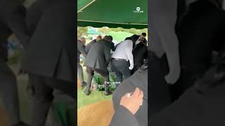 Pallbearers fall into grave at burial