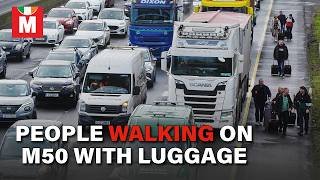 People Walking with Luggage on M50 Near Dublin as Fuel Protest Brings Traffic to Halt